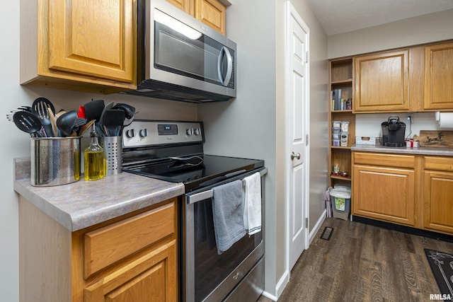 kitchen with appliances with stainless steel finishes and dark hardwood / wood-style floors