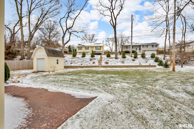 yard covered in snow featuring a garage and a storage shed