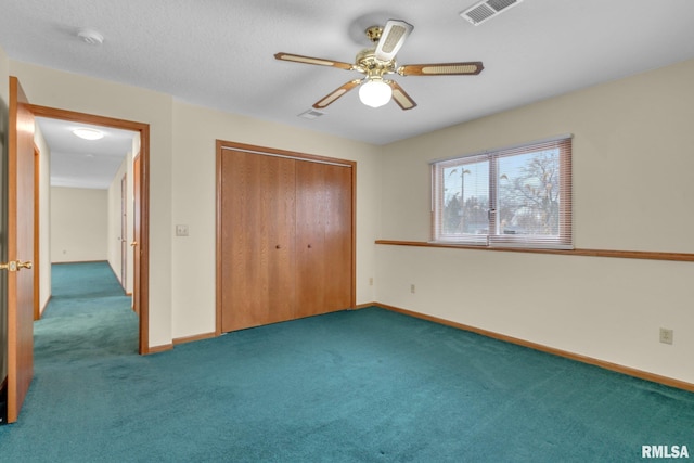 unfurnished bedroom featuring dark colored carpet, a closet, and ceiling fan