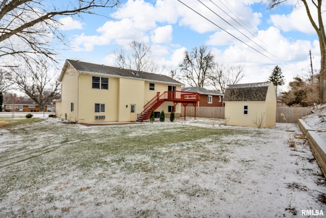 back of property featuring a yard, a shed, and a deck