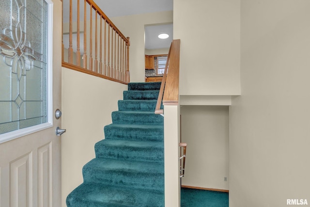 stairs featuring carpet flooring