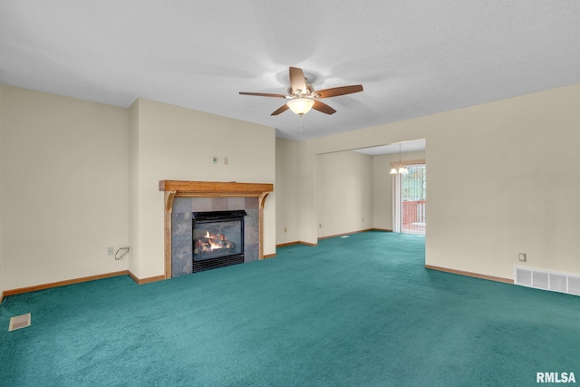 unfurnished living room with a fireplace, ceiling fan with notable chandelier, and carpet floors