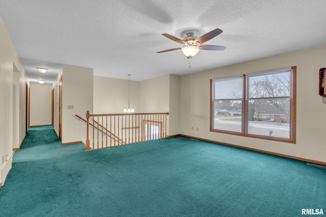 carpeted spare room with ceiling fan with notable chandelier