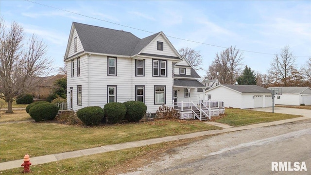 view of front of house with a front yard, a garage, an outdoor structure, and covered porch