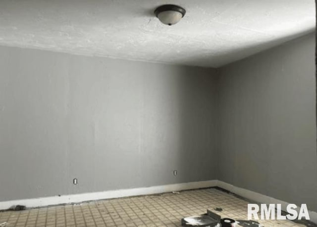 unfurnished room with a textured ceiling