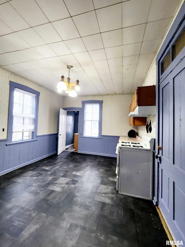 kitchen featuring a wealth of natural light, a notable chandelier, and range