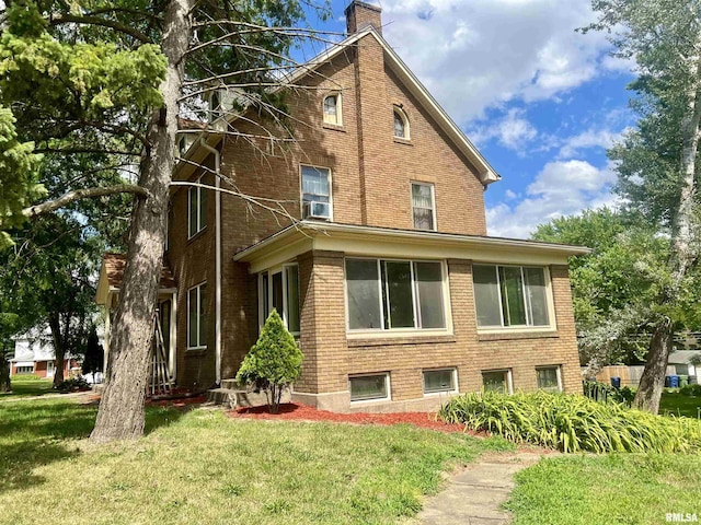 rear view of property featuring a lawn