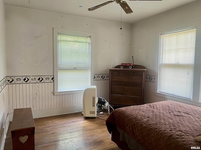 bedroom featuring multiple windows, ceiling fan, and hardwood / wood-style flooring