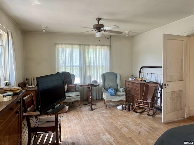 sitting room with ceiling fan and light wood-type flooring