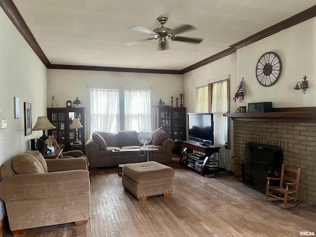 living room with hardwood / wood-style floors, ceiling fan, ornamental molding, and a fireplace