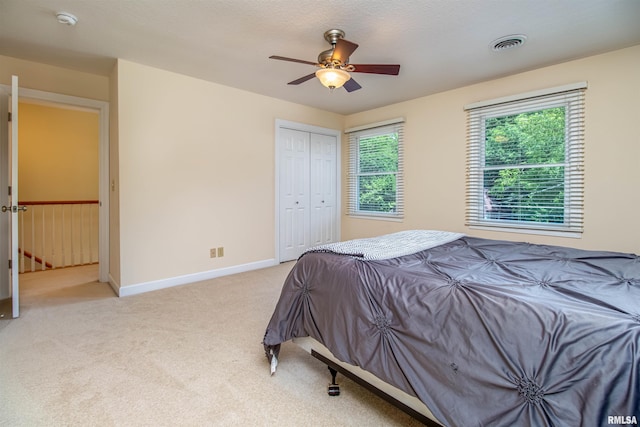 carpeted bedroom featuring a closet and ceiling fan