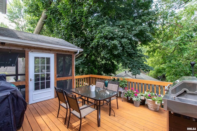 wooden deck with area for grilling and a sunroom