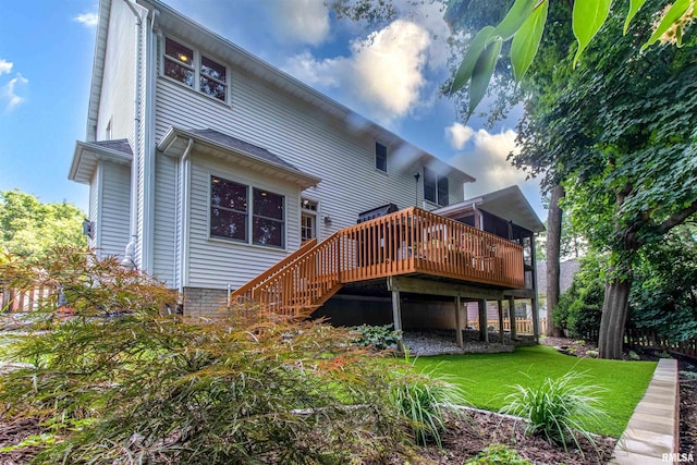 rear view of house with a deck and a lawn