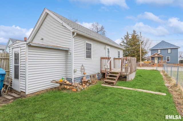 rear view of property featuring a wooden deck and a yard