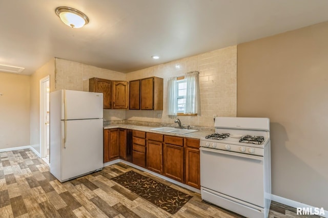 kitchen featuring light wood-type flooring, white appliances, and sink