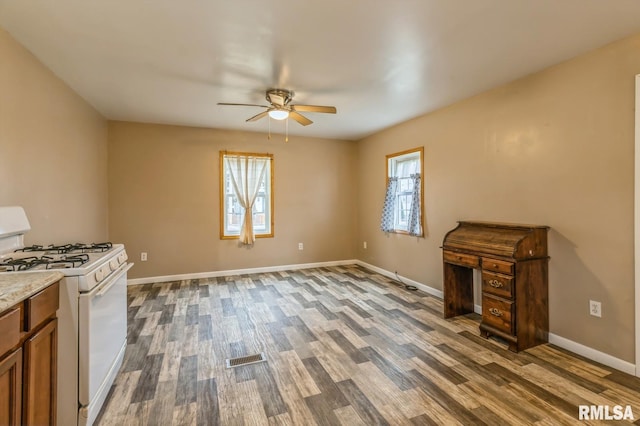 unfurnished living room with ceiling fan and dark hardwood / wood-style flooring