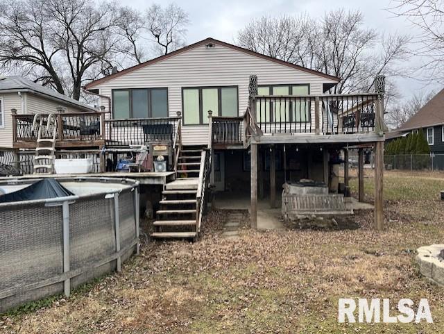 back of property featuring a pool side deck