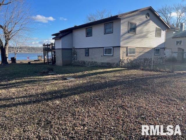 rear view of property with a lawn and a water view