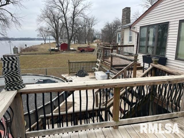 deck with a water view and a lawn