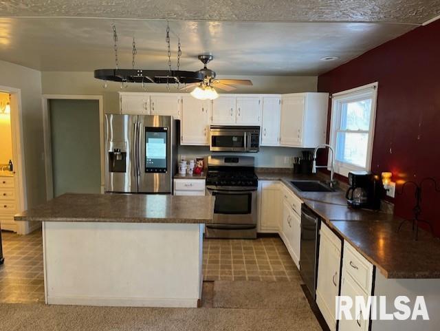 kitchen with white cabinets, appliances with stainless steel finishes, ceiling fan, and sink