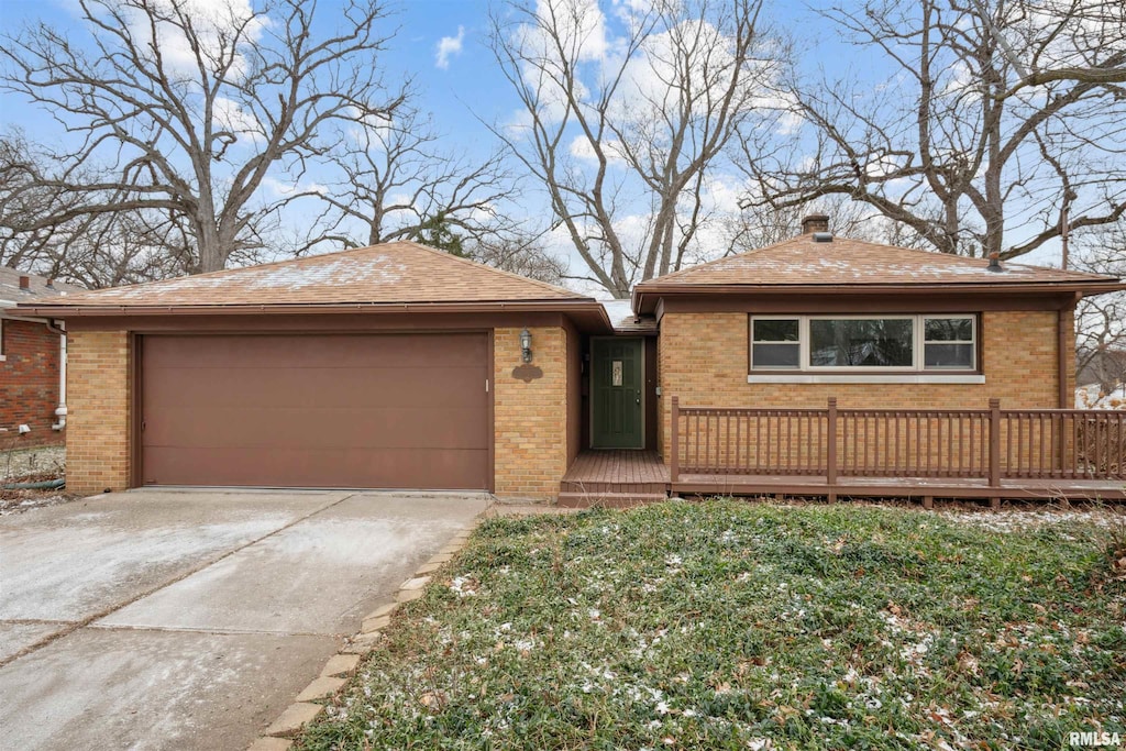 view of front of property with a wooden deck, a garage, brick siding, and concrete driveway