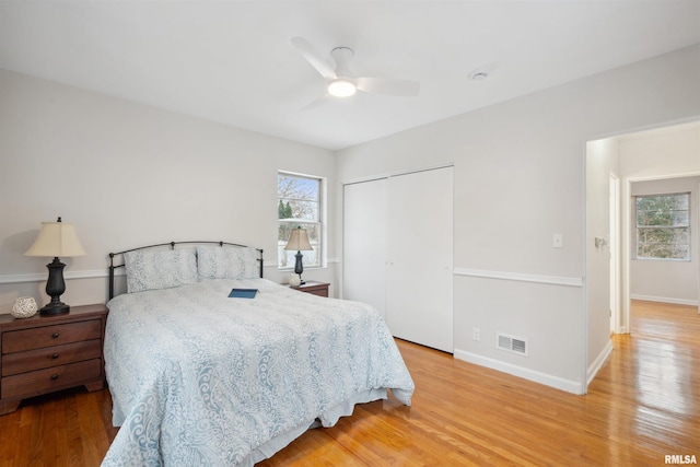 bedroom featuring light hardwood / wood-style flooring, a closet, and ceiling fan