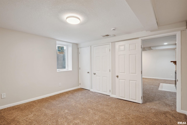 unfurnished bedroom with carpet floors and a textured ceiling