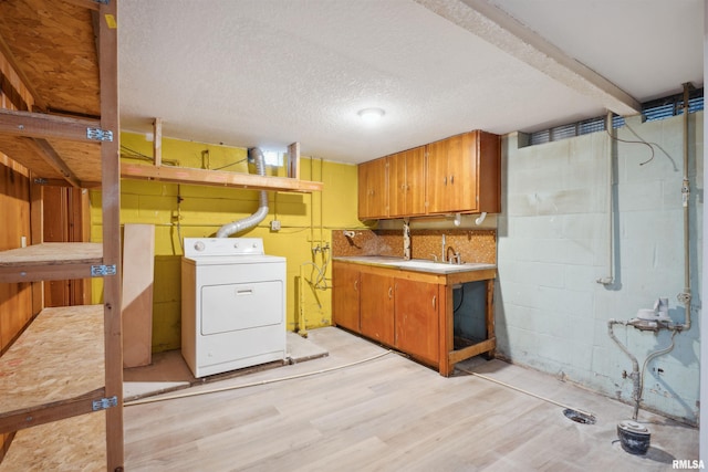 laundry room with washer / dryer, a textured ceiling, light wood-type flooring, sink, and cabinets