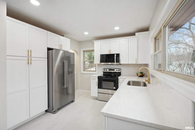 kitchen featuring sink, white cabinets, tasteful backsplash, and appliances with stainless steel finishes