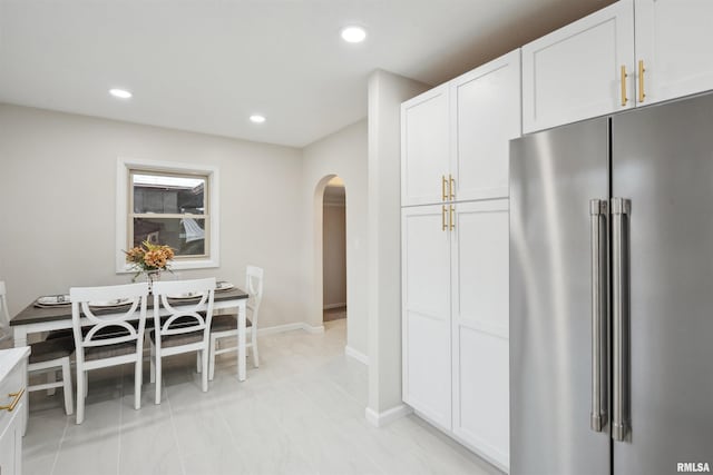 kitchen featuring light tile patterned floors, white cabinets, and high end refrigerator