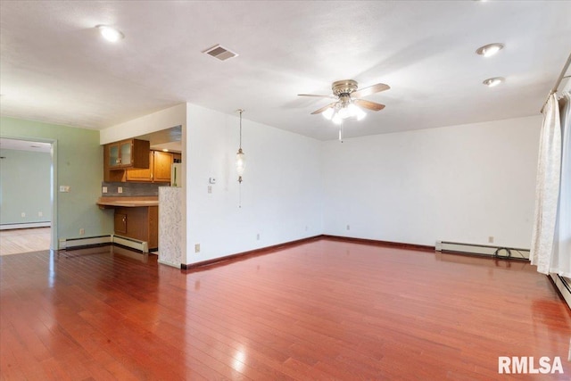 unfurnished living room featuring baseboard heating, ceiling fan, and hardwood / wood-style flooring