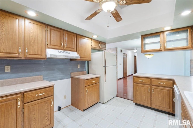 kitchen featuring decorative backsplash, ceiling fan, and white fridge