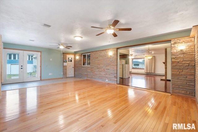 unfurnished living room featuring ceiling fan, light wood-type flooring, and french doors