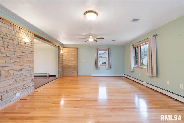 empty room featuring a baseboard radiator, light hardwood / wood-style flooring, and ceiling fan