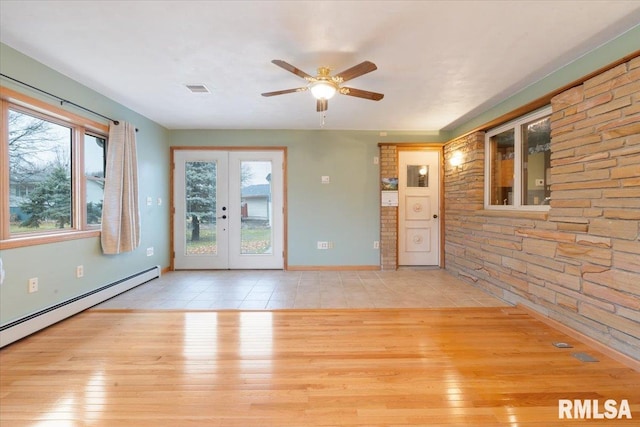 unfurnished living room featuring ceiling fan, french doors, plenty of natural light, and light wood-type flooring