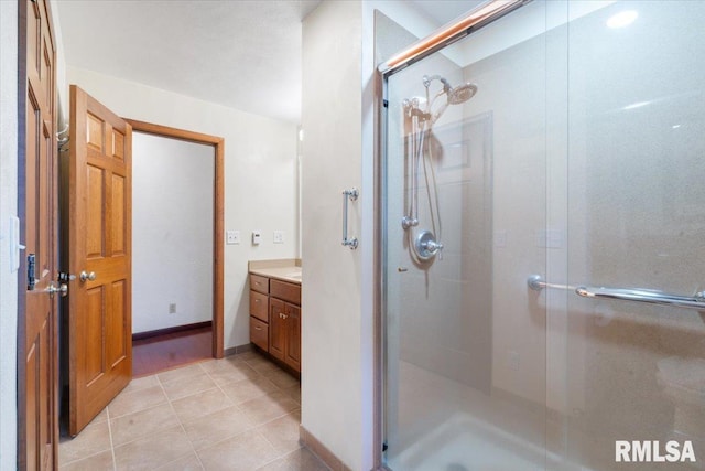 bathroom featuring tile patterned flooring, vanity, and a shower with door