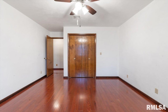 unfurnished bedroom featuring ceiling fan, dark hardwood / wood-style floors, and a closet