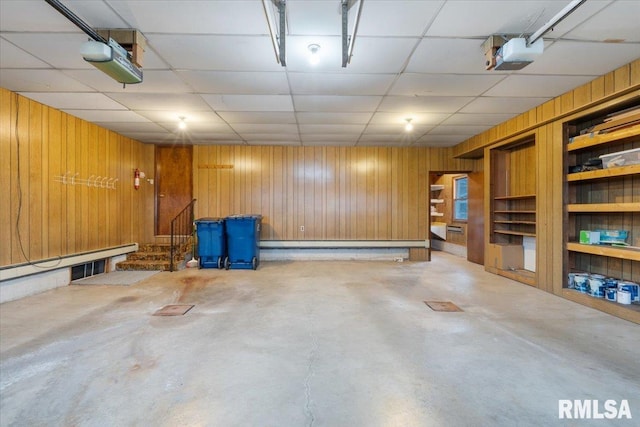 garage with wood walls and a garage door opener