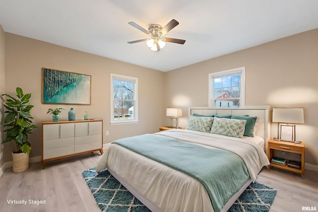 bedroom with multiple windows, ceiling fan, and light wood-type flooring