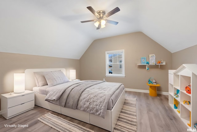 bedroom featuring ceiling fan, light hardwood / wood-style floors, and lofted ceiling