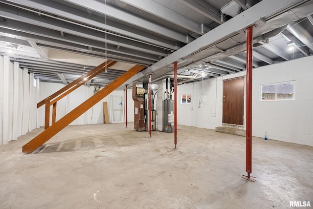 basement featuring heating unit and water heater