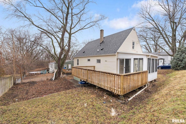 back of property featuring a sunroom, a yard, and a deck