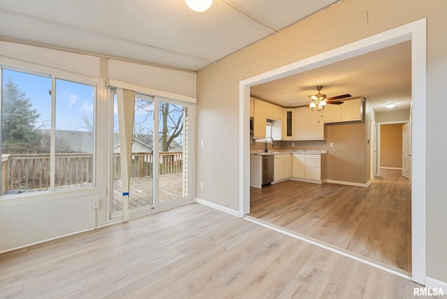 interior space with light hardwood / wood-style floors, ceiling fan, and sink