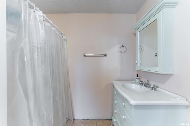 bathroom with tile patterned flooring, vanity, curtained shower, and a textured ceiling