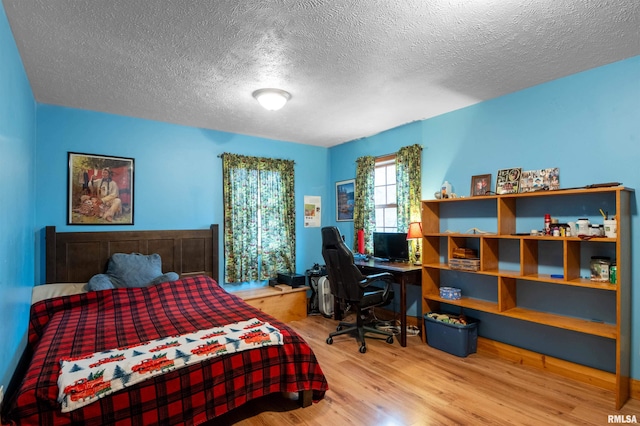 bedroom featuring wood-type flooring and a textured ceiling