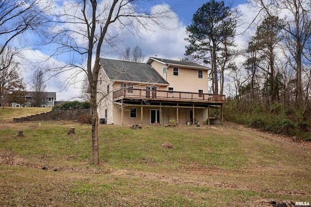 rear view of house featuring a lawn and a wooden deck