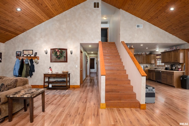 stairs with wood-type flooring and high vaulted ceiling