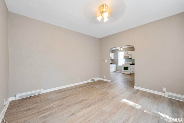 spare room with ceiling fan and light wood-type flooring