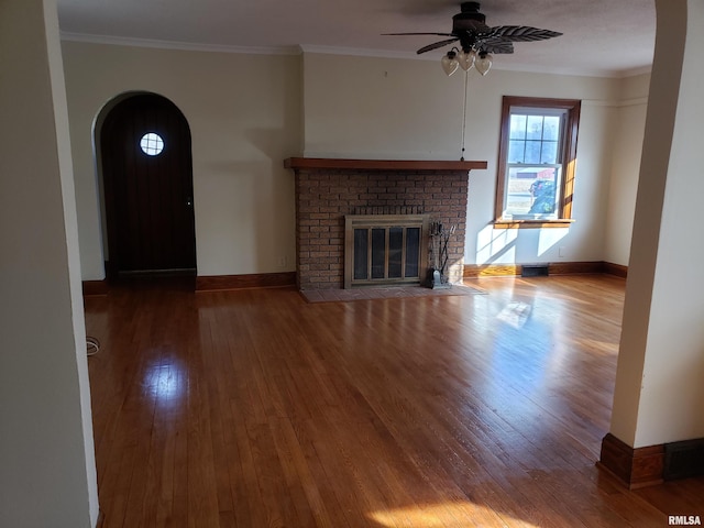 unfurnished living room with ornamental molding, wood-type flooring, a fireplace, and ceiling fan