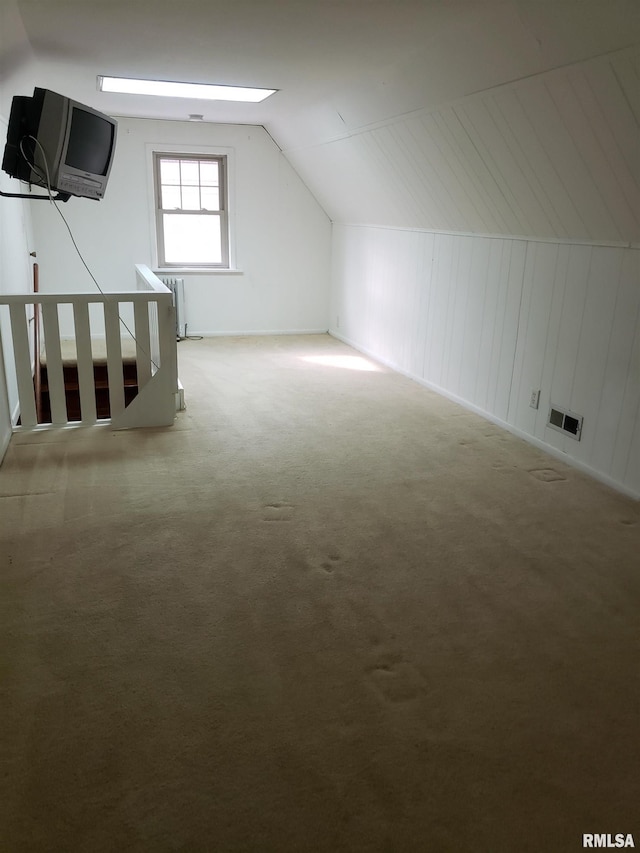 bonus room featuring carpet flooring, radiator, and vaulted ceiling